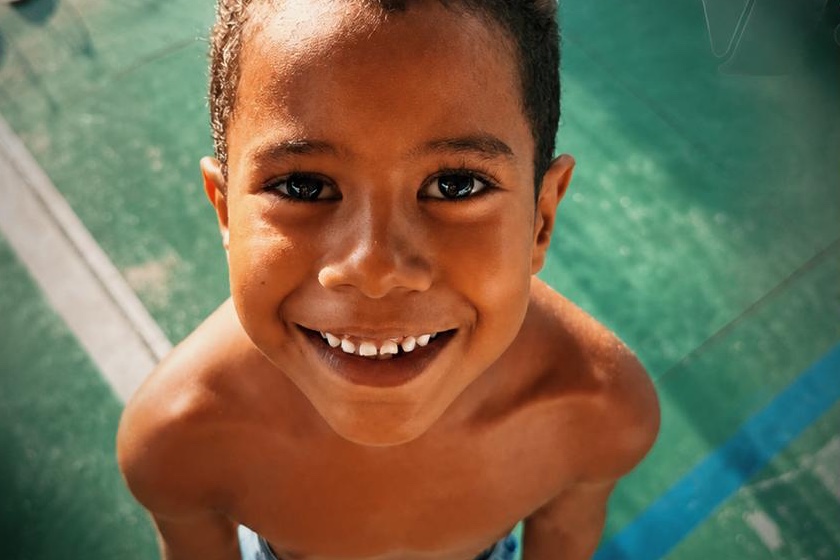 Menino atendido pelo Instituto sorrindo para a câmera